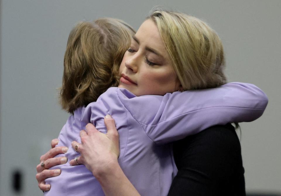 Amber Heard y Elaine Bredehoft se abrazan tras el fallo del jurado (REUTERS)