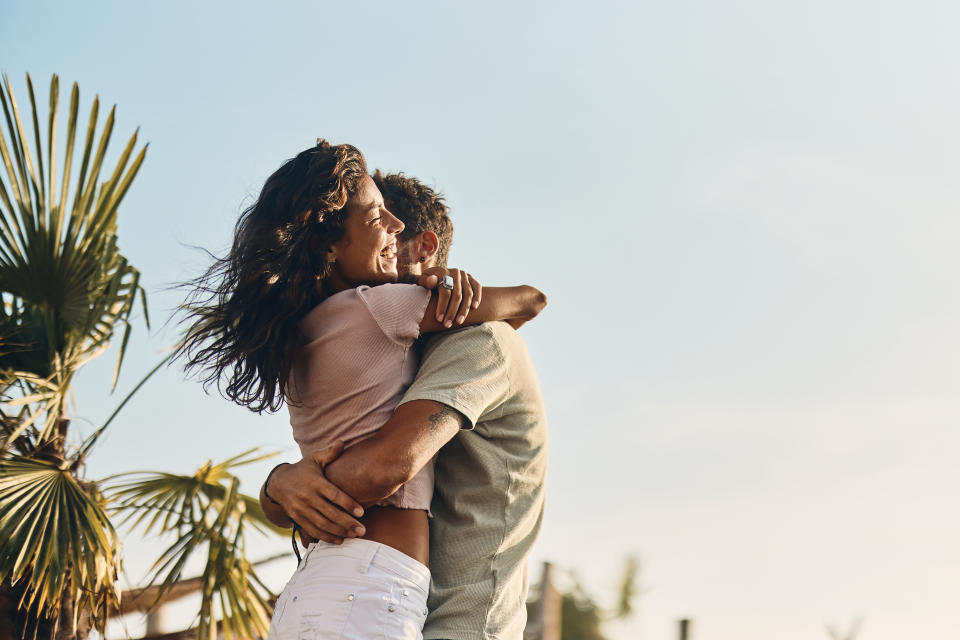 Affectionate couple embracing in summer day against the sky. Copy space.