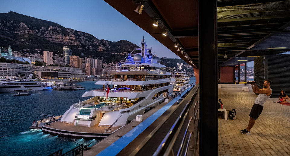 People workout in a quayside gym beside luxury superyacht Amadea in Monaco.