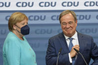 Chancellor Angela Merkel stands next to Governor Armin Laschet, right, the top CDU candidate after the German parliament elections at the Christian Democratic Union, CDU, party's headquarters in Berlin, Sunday, Sept. 26, 2021. German voters are choosing a new parliament in an election that will determine who succeeds Chancellor Angela Merkel after her 16 years at the helm of Europe's biggest economy. (AP Photo/Martin Meissner)