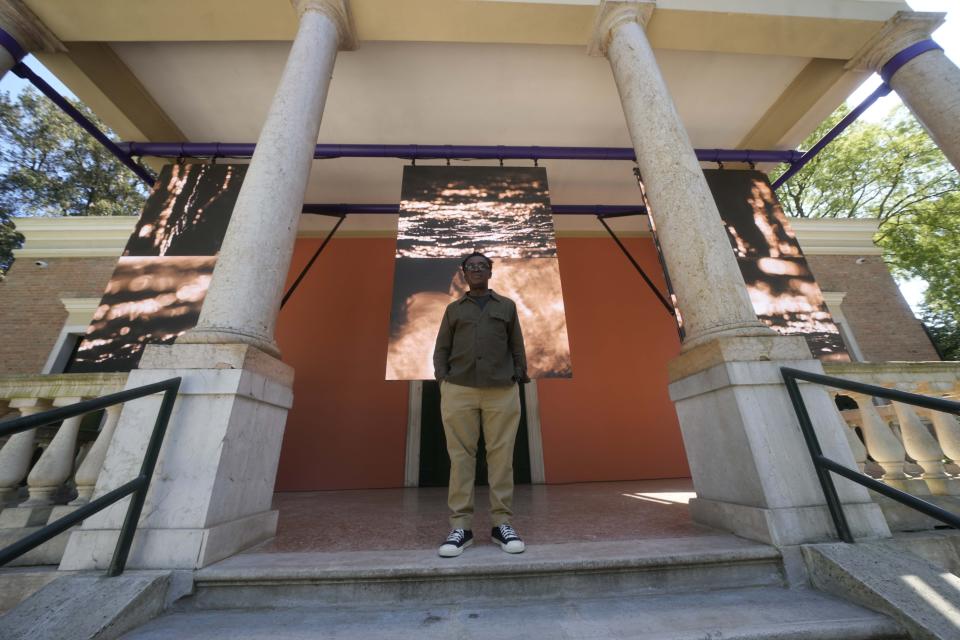 British artist John Akomfrah poses in front of the British pavilion at the 60th Biennale of Arts exhibition in Venice, Italy, Tuesday, April 16, 2024. The Venice Biennale contemporary art exhibition opens Saturday for its six-month run through Nov. 26. Alongside the main exhibition, 88 national pavilions fan out from the traditional venue in Venice's Giardini, to the Arsenale and other locations scattered throughout the lagoon city. (AP Photo/Luca Bruno)