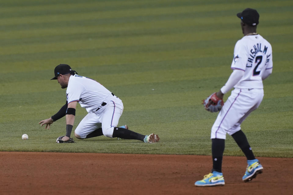 Miami Marlins shortstop Miguel Rojas (19) reaches for the ball after dropping the catch on a hit by Washington Nationals Luis Garcia during the sixth inning of a baseball game, Tuesday, Sept. 21, 2021, in Miami. To the right is Miami Marlins' second baseman Jazz Chisholm Jr. (2). (AP Photo/Marta Lavandier)