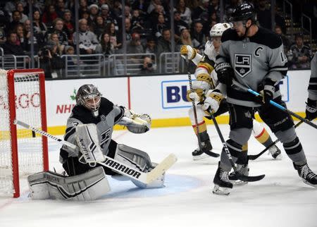 December 8, 2018; Los Angeles, CA, USA; Los Angeles Kings goaltender Jonathan Quick (32) blocks a shot as center Anze Kopitar (11) provides coverage against Vegas Golden Knights center Cody Eakin (21) during the second period at Staples Center. Gary A. Vasquez-USA TODAY Sports