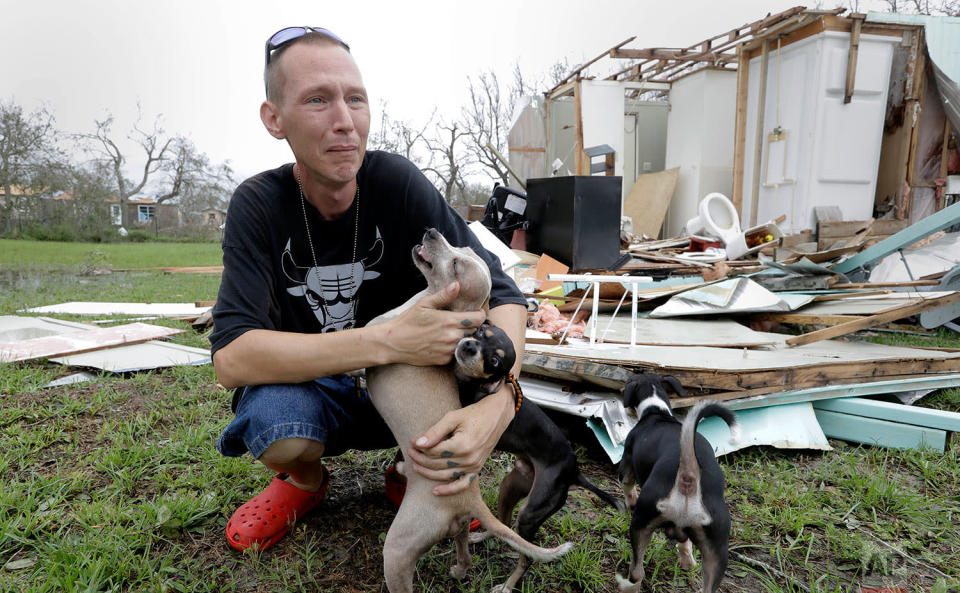 <p>Sam Speights tries to hold back tears while holding his dogs and surveying the damage to his home in the wake of Hurricane Harvey, Sunday, Aug. 27, 2017, in Rockport, Texas. (AP Photo/Eric Gay) </p>