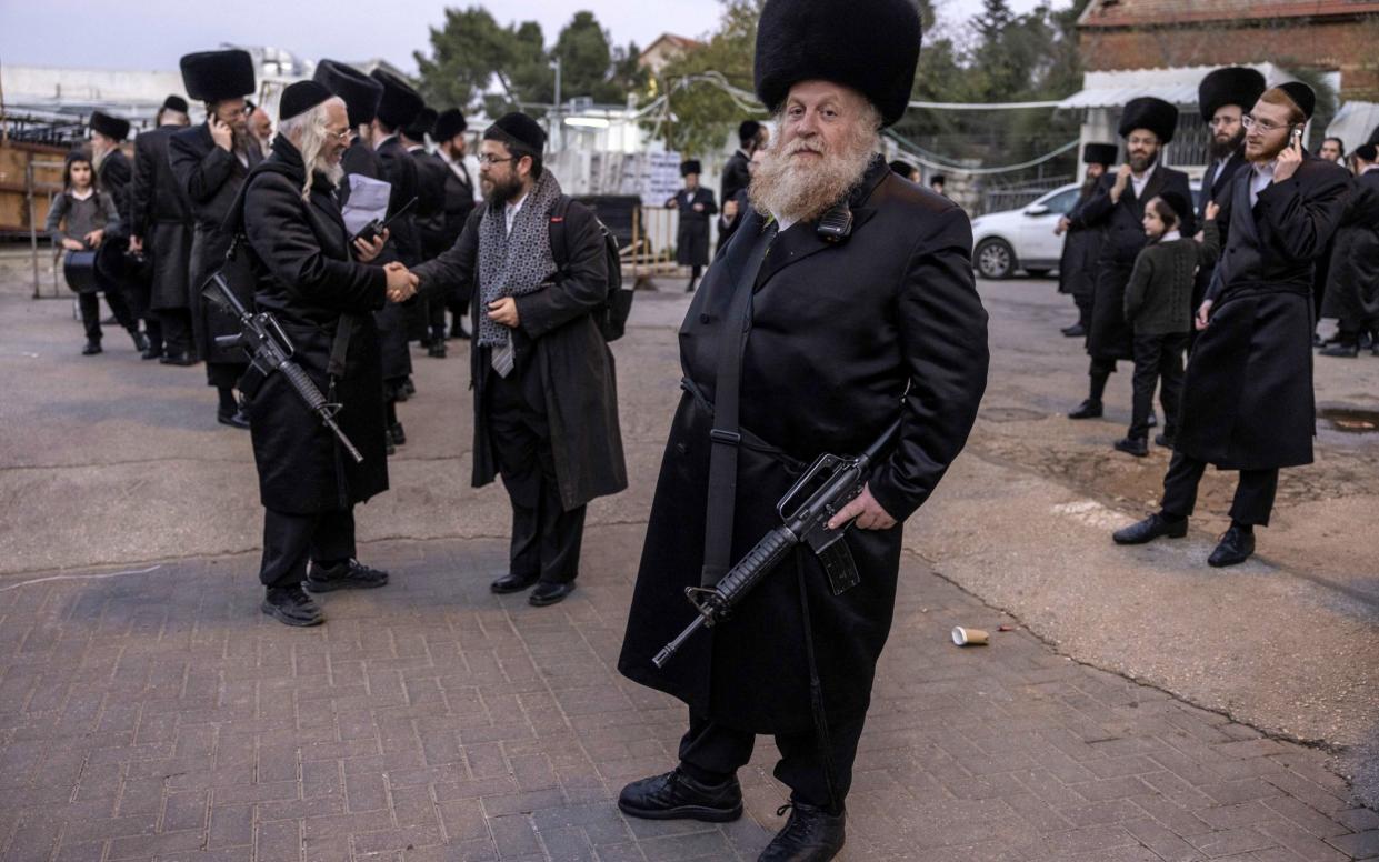 Jewish men of the Ger Hasidic dynasty and part of the first-response tactical team of their community stand guard during a wedding event in Jerusalem
