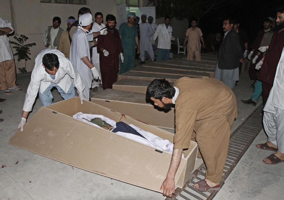 Medics close a coffin of a person killed from a roadside bomb in Kandahar, south of Kabul, Afghanistan, Monday, April 7, 2014. A roadside bomb killed at least 15 people traveling in vehicles that had been diverted from a main road Monday after an earlier attack in southern Afghanistan, officials said. (AP Photo/Allauddin Khan)