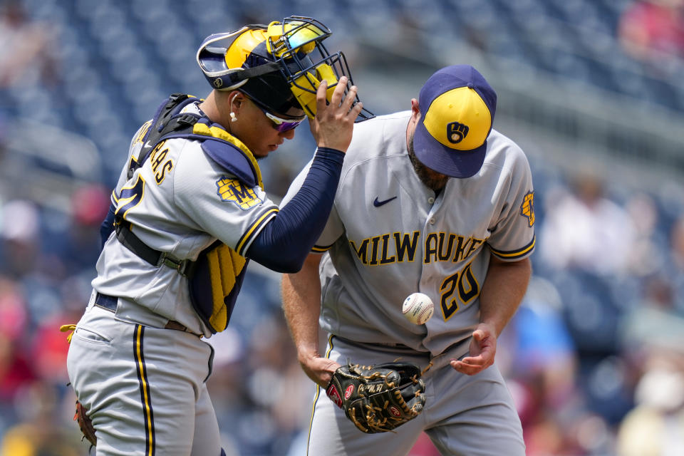 Milwaukee Brewers catcher William Contreras, left, and starting pitcher Wade Miley talk on the mound during the fourth inning of a baseball game against the Washington Nationals at Nationals Park, Wednesday, Aug. 2, 2023, in Washington. (AP Photo/Alex Brandon)