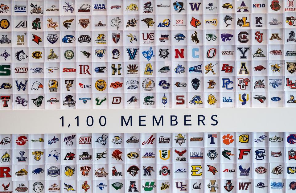 University logos cover a wall in the lobby of NCAA headquarters Thursday, Feb. 25, 2021, in Indianapolis. 