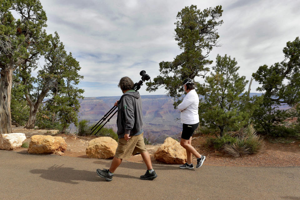 Visitors gather at the Grand Canyon Friday, May 15, 2020, in Grand Canyon, Ariz. Tourists are once again roaming portions of Grand Canyon National Park when it partially reopened Friday morning, despite objections that the action could exacerbate the coronavirus pandemic.(AP Photo/Matt York)