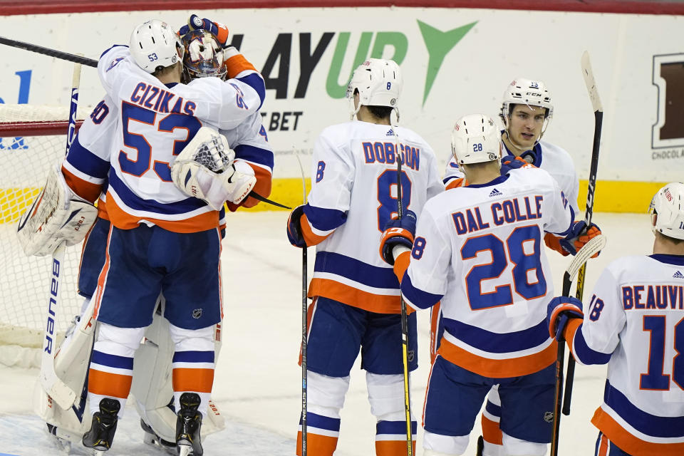 New York Islanders center Casey Cizikas (53) embraces goaltender Semyon Varlamov as teammates celebrate the team's win over the New Jersey Devils in an NHL hockey game Tuesday, March 2, 2021, in Newark, N.J. (AP Photo/Kathy Willens)