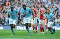 Manchester City's Gnegneri Toure Yaya (centre) runs off to celebrate after he scores the opening goal of the game