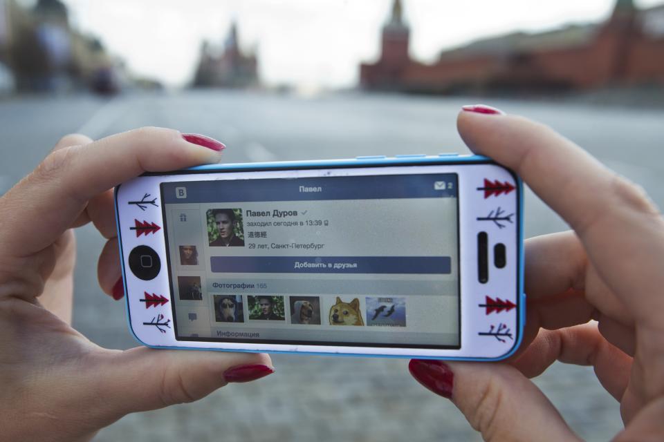 A user of Russia’s leading social network internet site VKontakte, poses holding an iPhone showing the account page of Pavel Durov, the former CEO and founder of VKontakte, in Red Square in Moscow, Russia, Wednesday, April 23, 2014. The network’s founder, Pavel Durov, described as Russia’s Mark Zuckerberg (founder of Facebook), left his post as CEO on Tuesday April 22, 2014, and is reported to have left Russia, one week after he posted online what he said were documents from the security services demanding personal details from 39 Ukraine-linked groups on VKontakte.(AP Photo/Pavel Golovkin)