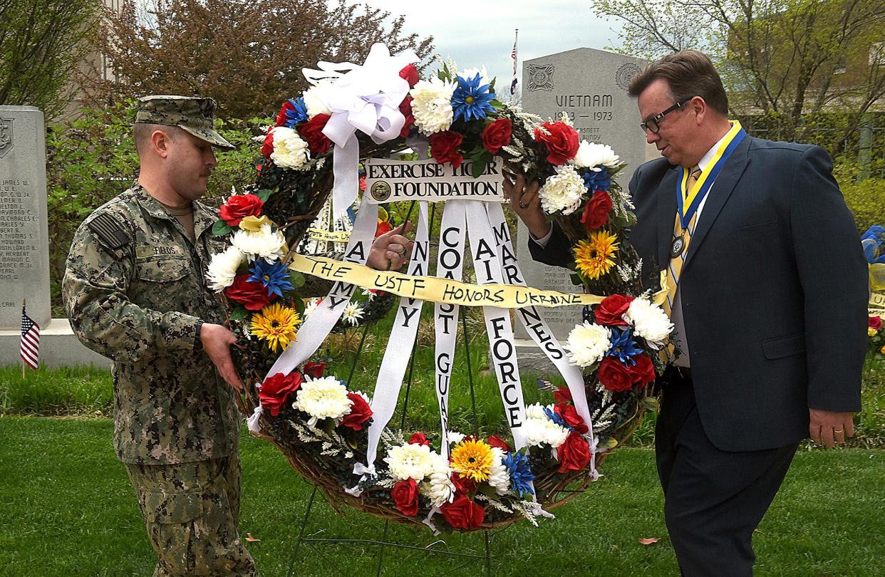 U.S. Navy Machinist's Mate Auxiliary First Class Kenneth Fields, left, and Midway Heights Baptist Church Pastor Scott Hanson carry an Exercise Tiger Foundation wreath honoring all branches of the U.S. military on Thursday during the United States Exercise Tiger Foundation Battle of Exercise Tiger & Ukraine Wreath Tribute at the Boone County Government Center. Ceremonies took place across the United States to honor soldiers killed in the World War II Battle of Exercise Tiger and Ukrainian soldiers fighting the Russian invasion of Ukraine.