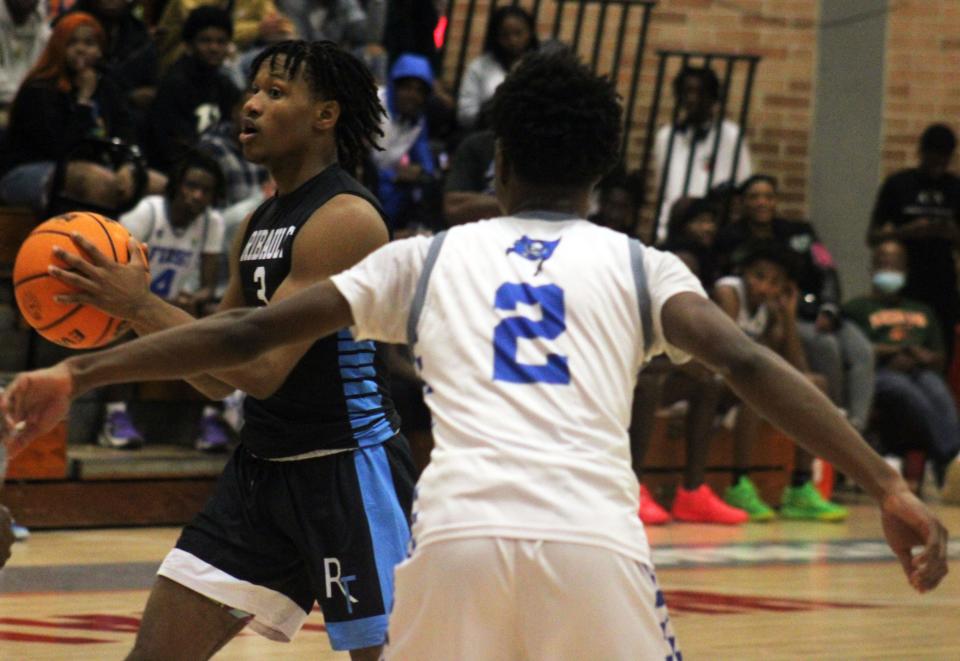 Ribault guard Caleb Williams (3) looks for a passing lane as First Coast's Markel Mitchell (2) defends.