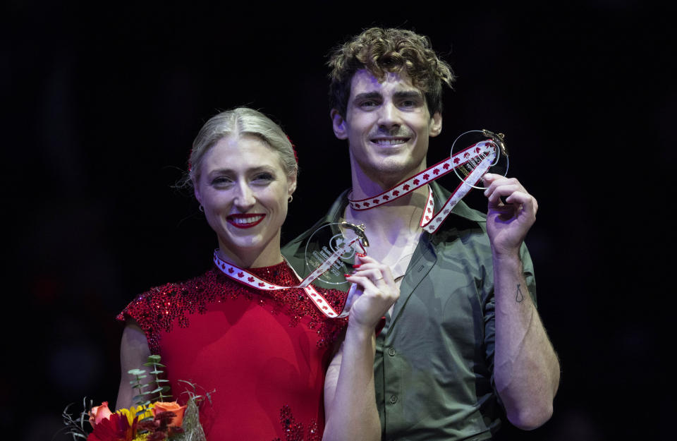 Ice dance gold medalists Canada's Piper Gilles and Paul Poirier hold up their medals during victory ceremonies at the Skate Canada International figure skating competition in Mississauga, Ontario, on Saturday, Oct. 29, 2022. (Paul Chiasson/The Canadian Press via AP)