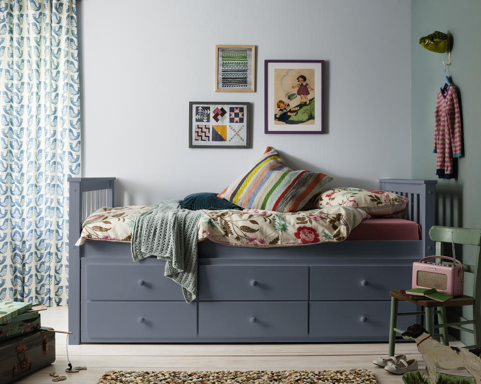 kids' room with gray day bed with storage, green and blue walls, green vintage chair