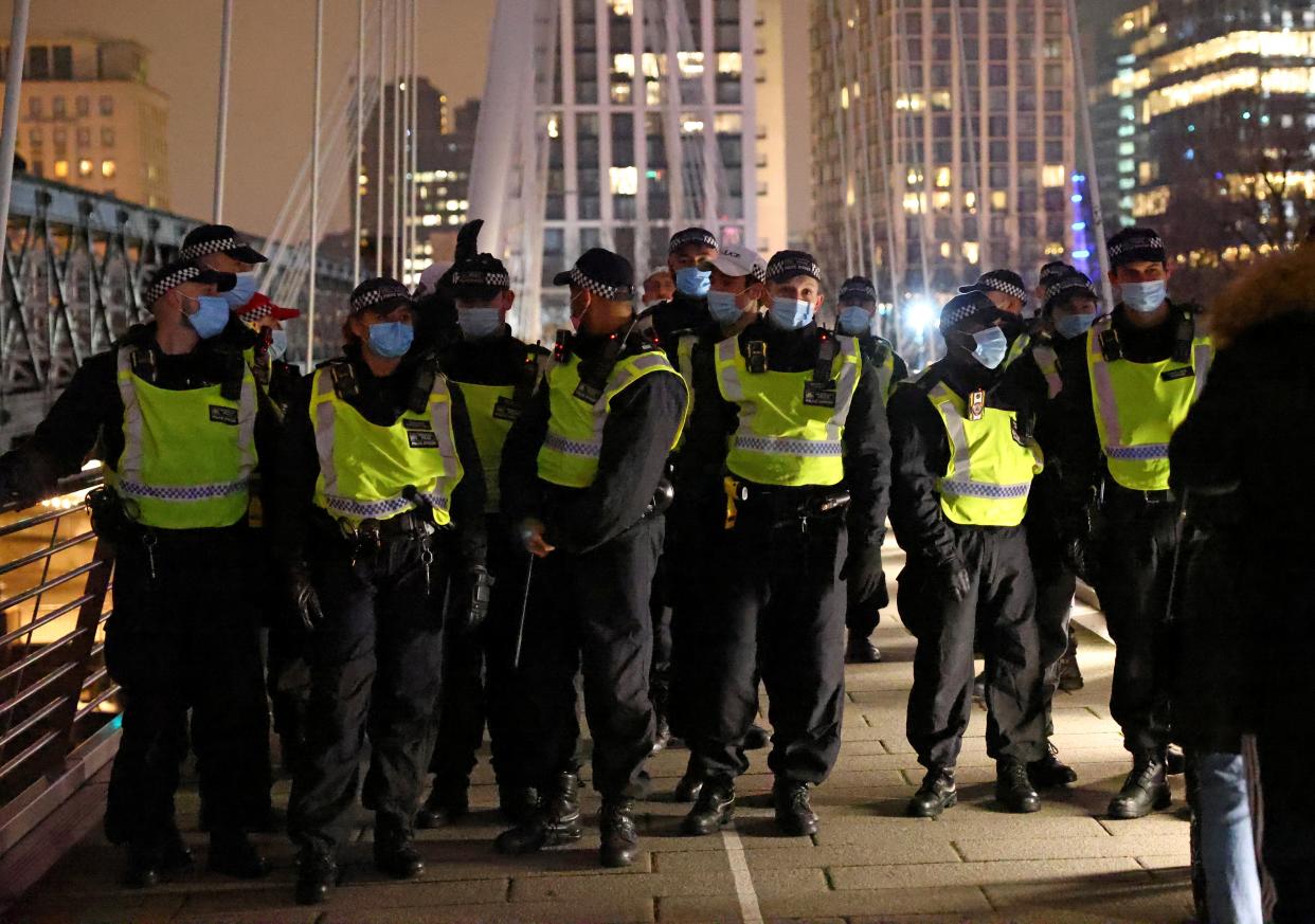 <p>Police officers during an anti-lockdown demonstration in central London on Thursday night</p> (Reuters)