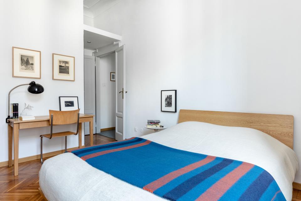 In the main bedroom, Alex topped a Muji bed with a Rocabar blanket by Hermès and bed linens by Libeco. A 1930s gelatin silver print by Albert Renger-Patzsch hangs next to the bed, while prints by Hans Rudolphi from 1925 are displayed above a Muji desk and 1930s lamp by Christian Dell for Kaiser Idell.