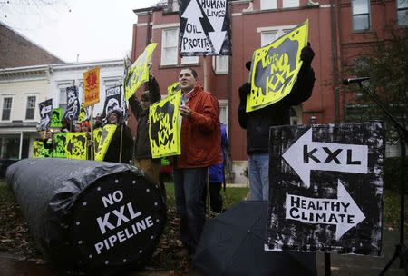 Climate advocates and representatives from the Rosebud Sioux Tribe in South Dakota protest against the Keystone XL pipeline in front of the home (center) of U.S. Senator Mary Landrieu (D-LA), chair of the Senate Energy Committee, in Washington November 17, 2014. REUTERS/Gary Cameron