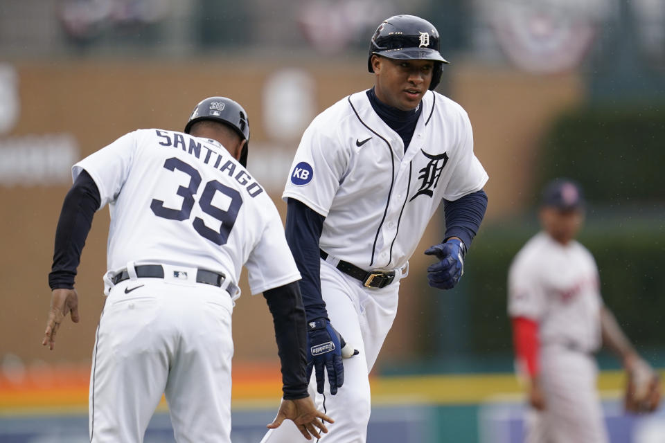 Detroit Tigers' Jonathan Schoop (7) celebrates his home run with third base coach Ramon Santiago (39) against the Boston Red Sox in the first inning of a baseball game in Detroit, Wednesday, April 13, 2022. (AP Photo/Paul Sancya)