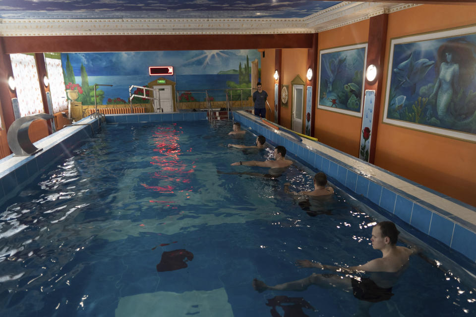 Ukrainian soldier take part in an aquatic therapy session in a hot pool at a rehabilitation center in Kharkiv region, Ukraine, Friday, Dec. 30, 2022. The relentless 10-month war has prompted a local commander to transform an old soviet-era sanatorium into a recovery center for servicemen to treat both mental and physical ailments. (AP Photo/Vasilisa Stepanenko)