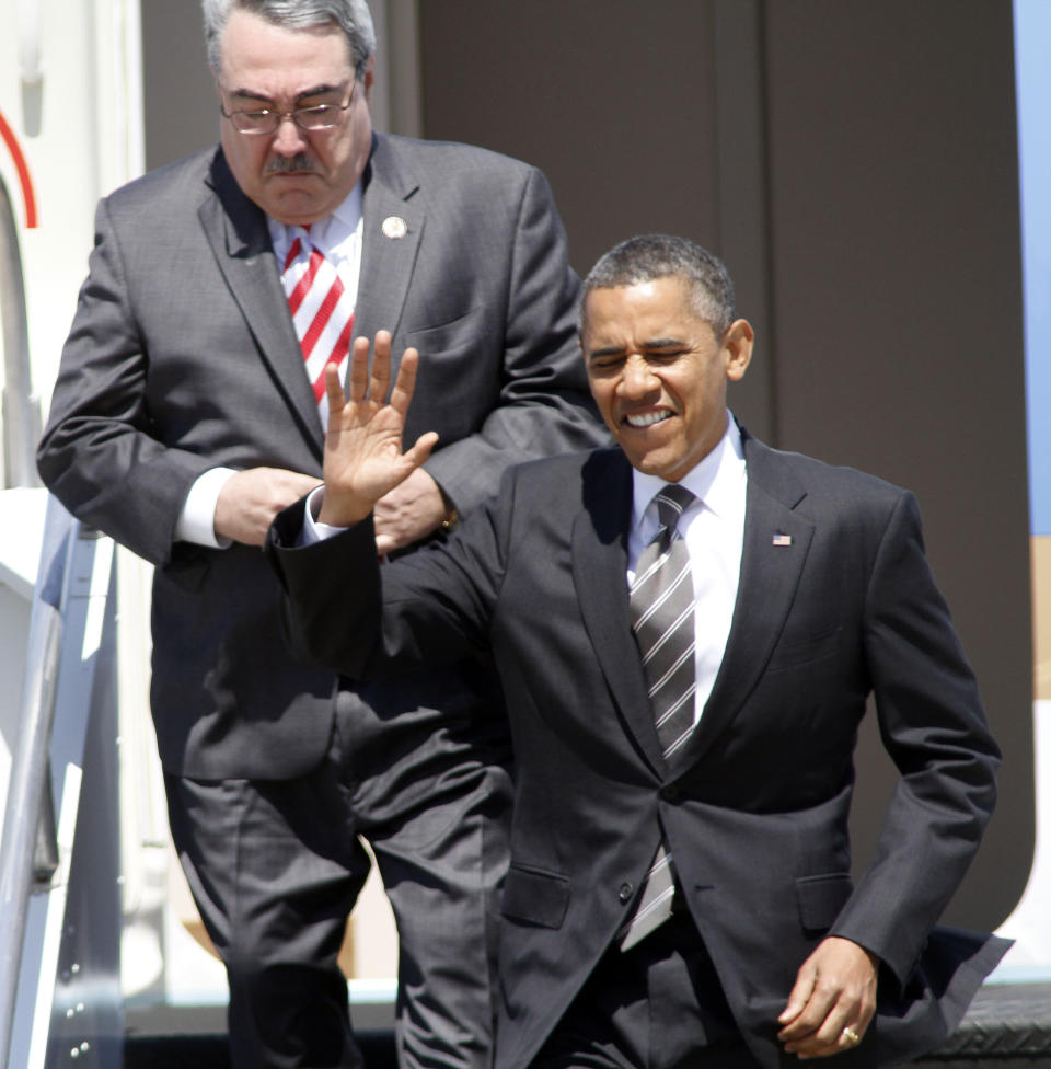 President Barack Obama, followed by Rep. G.K. Butterfield, D-N.C., waves as they exit Air Force One upon arrival at Raleigh Durham International Airport in Morrisville, N.C., Tuesday, April 24, 2012. (AP Photo/Jim R. Bounds)