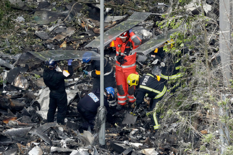 <p>Emergency workers search debris that fell at the base of the fire-gutted Grenfell Tower in London, Friday, June 16, 2017, after a fire engulfed the 24-story building Wednesday morning. (Photo: Matt Dunham/AP) </p>