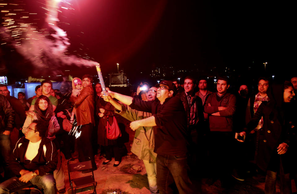 In this picture taken on Tuesday, March 18, 2014, two Iranian men light fireworks during a celebration, known as “Chaharshanbe Souri,” or Wednesday Feast, marking the eve of the last Wednesday of the solar Persian year, in Pardisan park, Tehran, Iran. The festival has been frowned upon by hard-liners since the 1979 Islamic revolution because they consider it a symbol of Zoroastrianism, one of Iran’s ancient religions of Iranians. They say it goes against Islamic traditions. (AP Photo/Vahid Salemi)