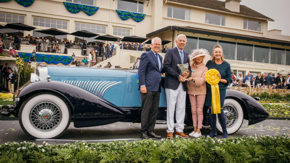 Sandra Button, chairman of the Pebble Beach Concours d’Elegance (right) and David Stivers, CEO of the Pebble Beach Company (left) award Lee and Penny Anderson Best of Show for their 1932 Duesenberg J Figoni Sports Torpedo. - Credit: Tom O'Neal, courtesy of Rolex.