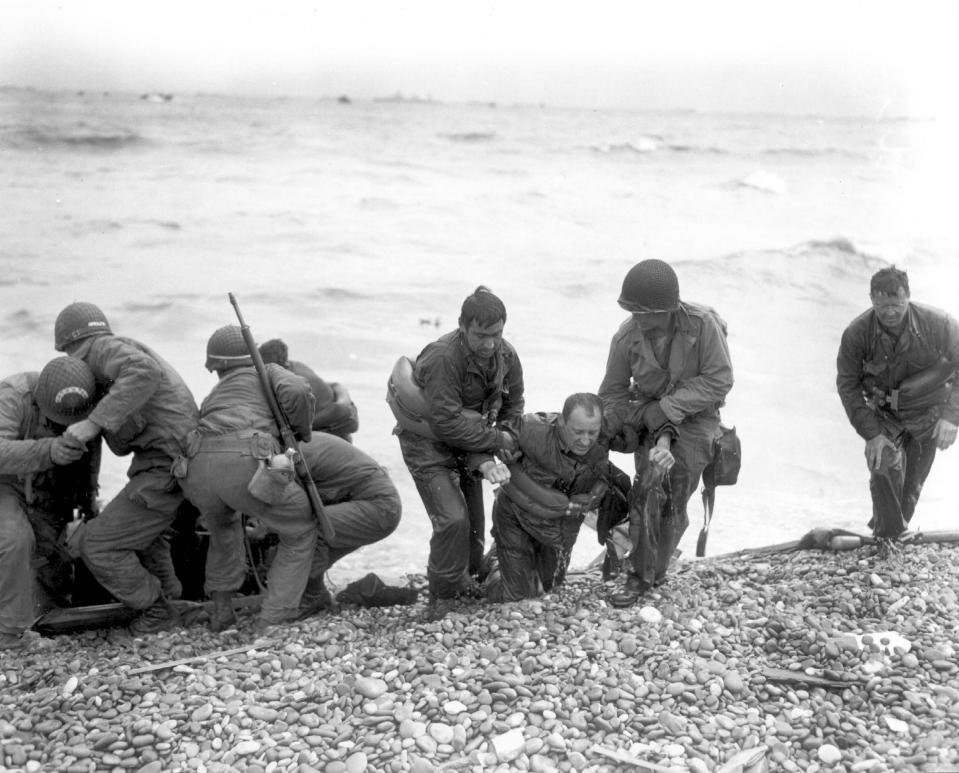 Members of an American landing party assist troops whose landing craft was sunk by enemy fire off Omaha Beach, near Colleville-sur-Mer, France, on June 6, 1944. (Photo: Weintraub/U.S. National Archives/handout via Reuters)