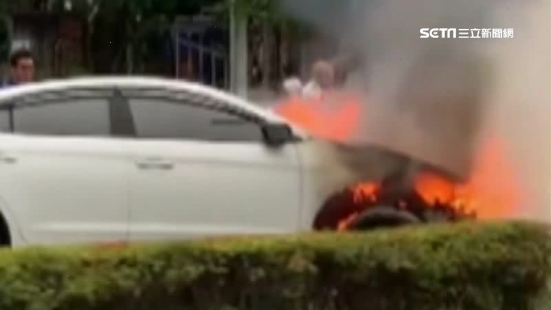 轎車車頭起火燃燒，還伴隨大量白煙遮蔽車道視線。