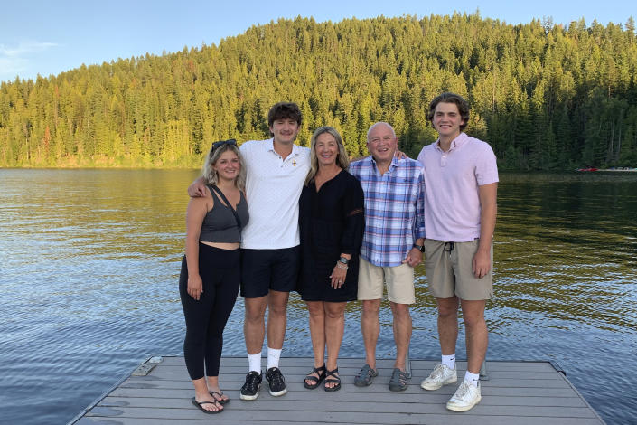 In this photo provided by Stacy Chapin, triplets Maizie, left, Ethan, second from left, and Hunter, right, pose with their parents Stacy and Jim Chapin at Priest Lake in northern Idaho in July 2022. Ethan Chapin was one of four University of Idaho students found stabbed to death in a home near the Moscow, Idaho campus on Sunday, Nov. 13, 2022. Police are still searching for a suspect in the case.(Stacy Chapin via AP)