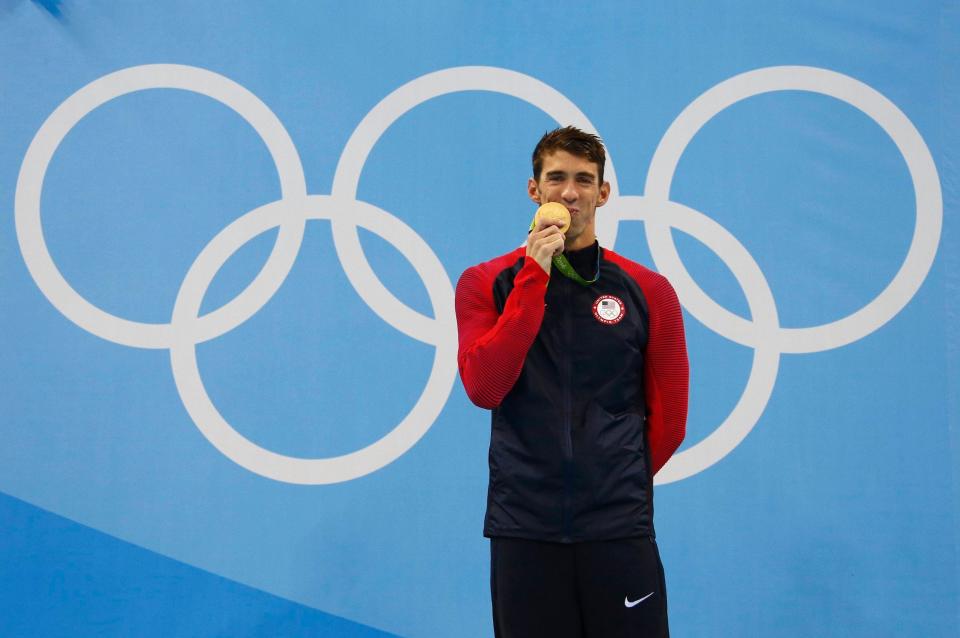 Michael Phelps poses with a gold medal from the 2016 Rio Olympics.