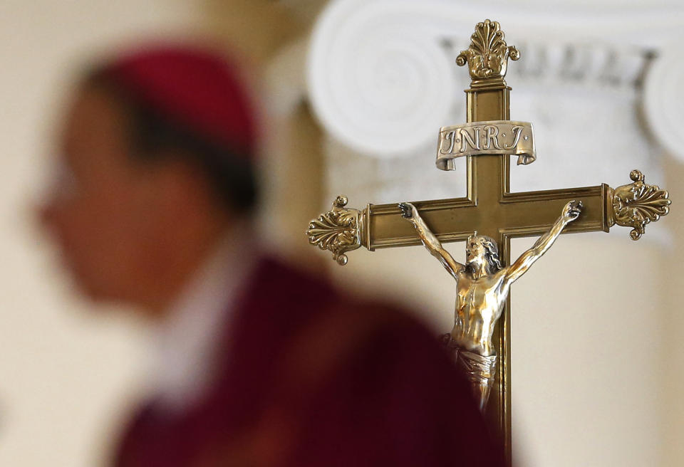 A crucifix stands behind Baltimore Archbishop William Lori as he delivers a homily during an Ash Wednesday Mass in Baltimore, Wednesday, March 5, 2014. Ash Wednesday marks the beginning of the Lenten season, a time when Christians commit to acts of penitence and prayer in preparation for Easter Sunday. (AP Photo/Patrick Semansky)