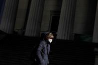 A woman in a face mask walks in the downtown area of Manhattan, New York City, after further cases of coronavirus were confirmed in New York