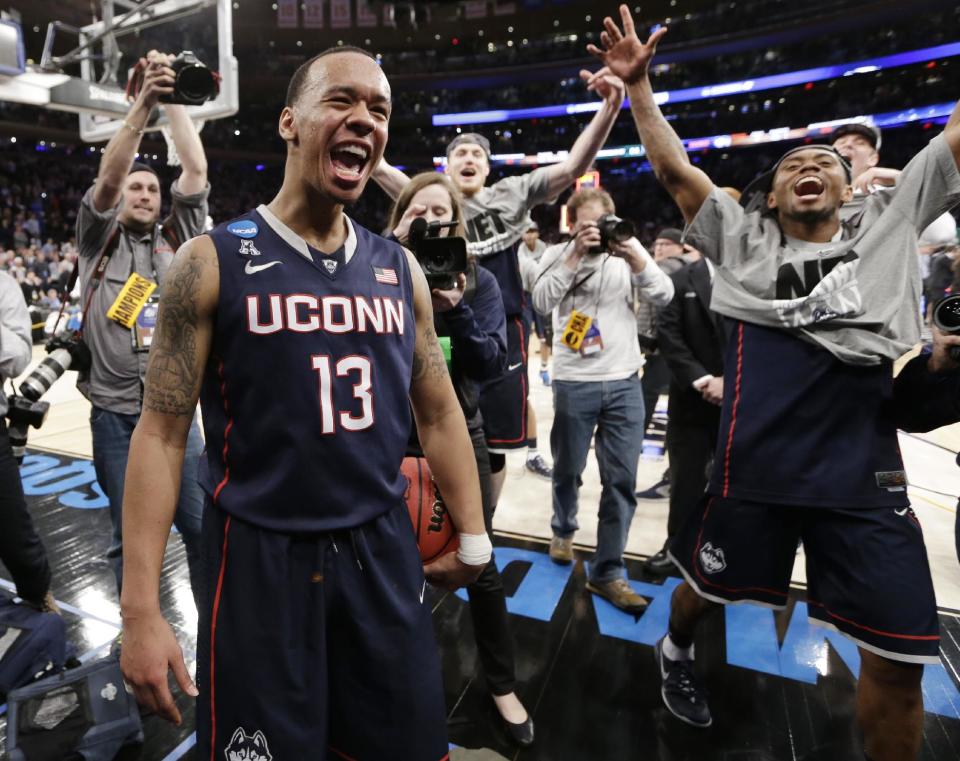 Connecticut's Shabazz Napier (13) celebrates after his team defeated Michigan State 60-54 in a regional final at the NCAA college basketball tournament, Sunday, March 30, 2014, in New York. Napier scored 17 points of his 25 points in the second half. (AP Photo/Frank Franklin II)