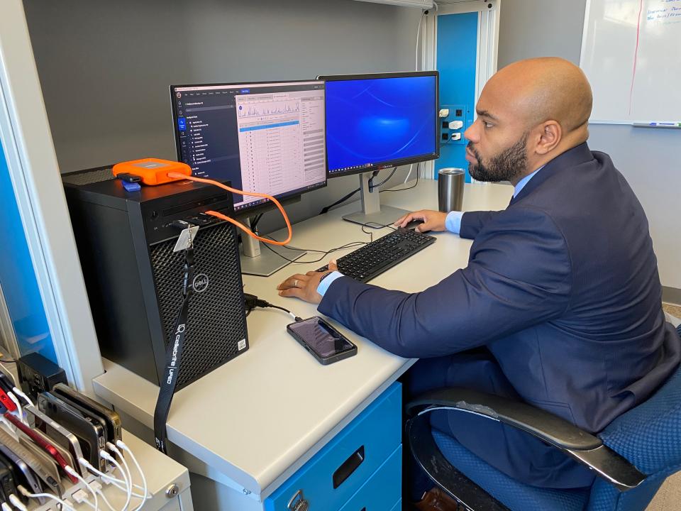 Providence police Detective Joseph Nezier works to transfer data from a cellphone in the department's new Digital Intelligence Unit.