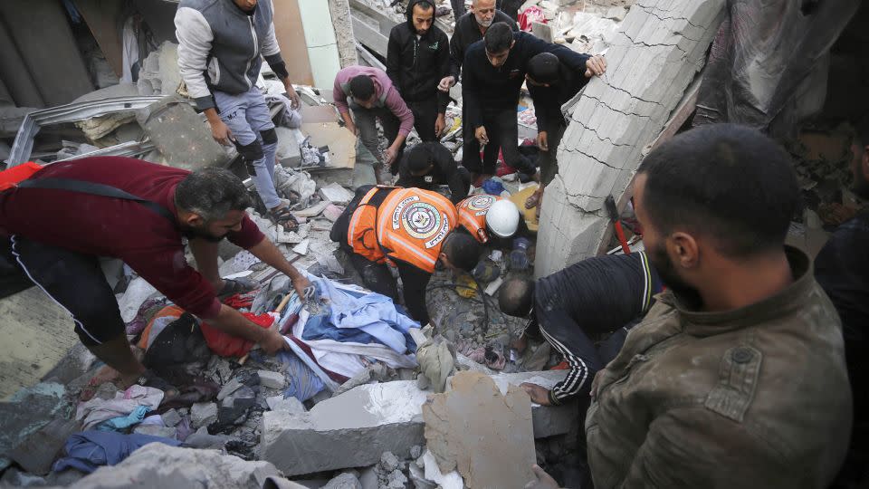 Palestinians gather to conduct a search and rescue operation among rubble of buildings following the end of the week-long 'humanitarian pause' in Deir Al Balah, Gaza on Friday. - Ashraf Amra/Anadolu/Getty Images