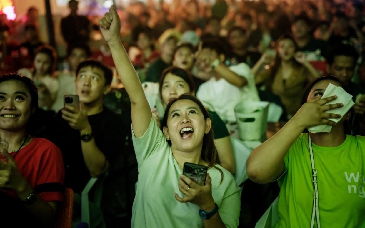 Indonesia supporters react as they watch giant screens the U23 AFC Qatar 2024 Asian Cup semi-final football match between Indonesia and Uzbekistan, played in Doha, in Jakarta on April 29, 202