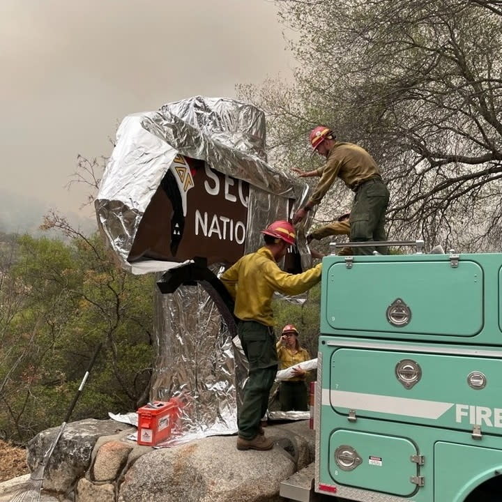 Firefighters cover a sign at Sequoia National Park