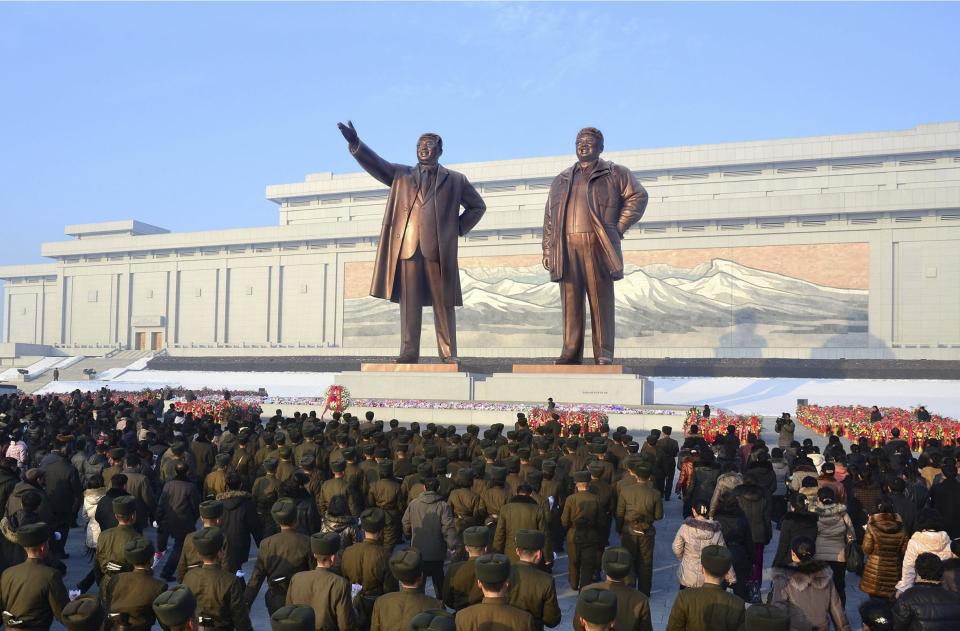 North Koreans offer flowers in front of statues of North Korea's founder Kim Il Sung and former leader Kim Jong Il at Mansudae hill in Pyongyang, on the second anniversary of the death of Kim Jong Il, in this undated photo released by North Korea's Korean Central News Agency (KCNA) in Pyongyang on December 17, 2013. REUTERS/KCNA (NORTH KOREA - Tags: POLITICS ANNIVERSARY) ATTENTION EDITORS - THIS PICTURE WAS PROVIDED BY A THIRD PARTY. REUTERS IS UNABLE TO INDEPENDENTLY VERIFY THE AUTHENTICITY, CONTENT, LOCATION OR DATE OF THIS IMAGE. FOR EDITORIAL USE ONLY. NOT FOR SALE FOR MARKETING OR ADVERTISING CAMPAIGNS. THIS PICTURE IS DISTRIBUTED EXACTLY AS RECEIVED BY REUTERS, AS A SERVICE TO CLIENTS. NO THIRD PARTY SALES. NOT FOR USE BY REUTERS THIRD PARTY DISTRIBUTORS. SOUTH KOREA OUT. NO COMMERCIAL OR EDITORIAL SALES IN SOUTH KOREA