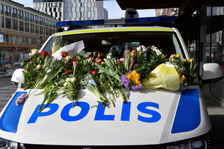 People leaving flowers on a police van outside Ahlens department store following Friday's terror attack in central Stockholm, Sweden, Sunday, April 9, 2017. Jonas Ekstromer/TT News Agency via REUTERS
