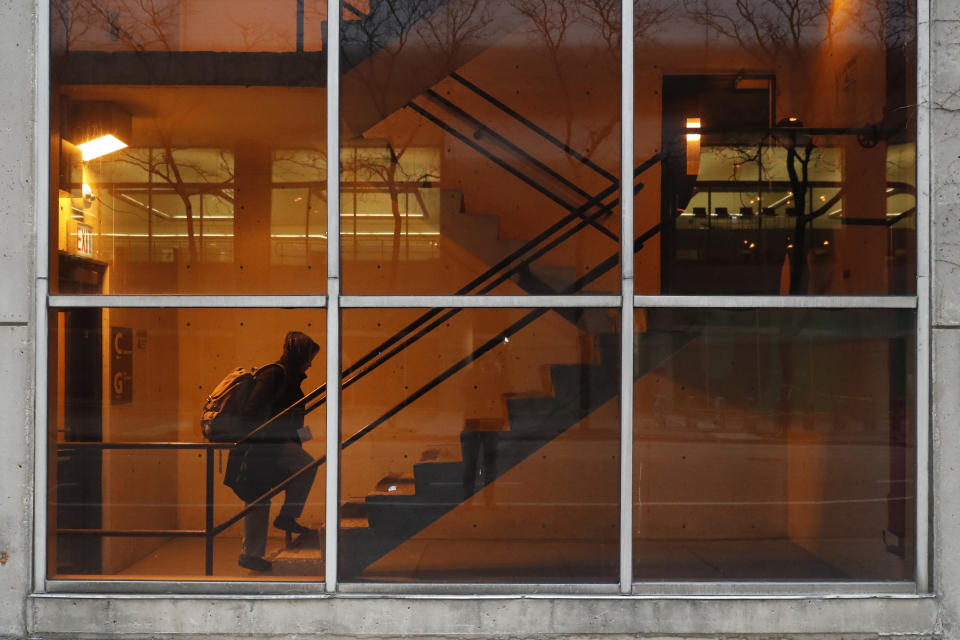 In this Wednesday, April 22, 2020, RUSH Hospital respiratory therapist Jumana Azam heads to a garage walkway before starting her early morning shift at the hospital in Chicago. (AP Photo/Charles Rex Arbogast)