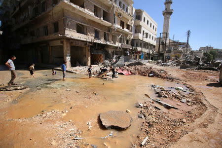 Children play with water from a burst water pipe at a site hit yesterday by an air strike in Aleppo's rebel-controlled al-Mashad neighbourhood, Syria, September 30, 2016. REUTERS/Abdalrhman Ismail