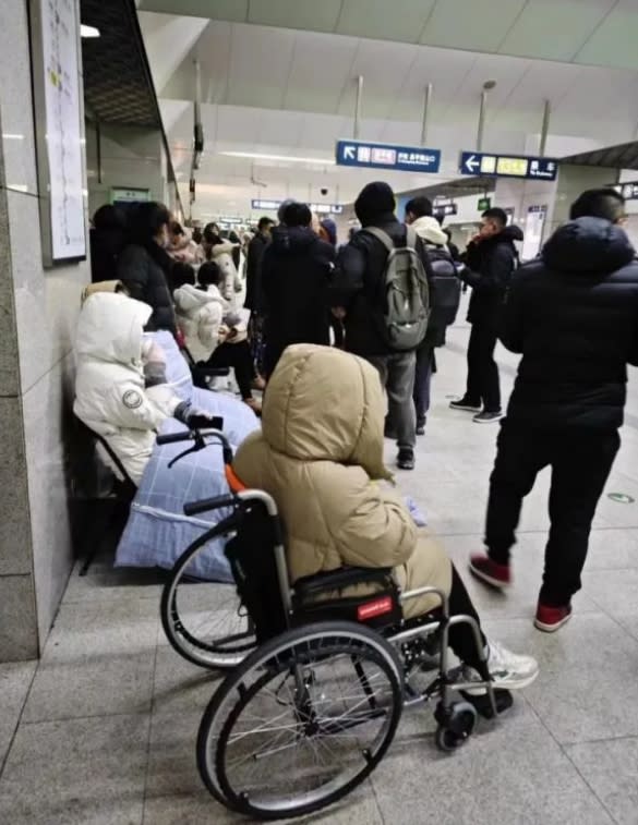 北京地鐵追尾事故，受傷的民眾坐在輪椅上，等著送醫治療。   圖 : 翻攝自微博