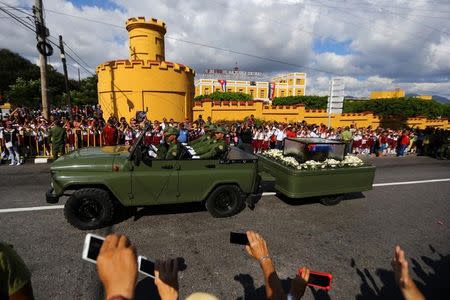 The ashes of former Cuban President Fidel Castro are driven past the Moncada Army Barracks, where Castro led a failed assault in 1953 that sparked the movement that eventually toppled the U.S.-backed government of dictator Fulgencio Batista, in Santiago de Cuba, Cuba, December 3, 2016. REUTERS/Ivan Alvarado