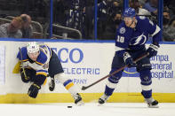 St. Louis Blues defenseman Scott Perunovich (48) gets tripped up by Tampa Bay Lightning right wing Corey Perry (10) during the first period of an NHL hockey game Thursday, Dec. 2, 2021, in Tampa, Fla. (AP Photo/Chris O'Meara)