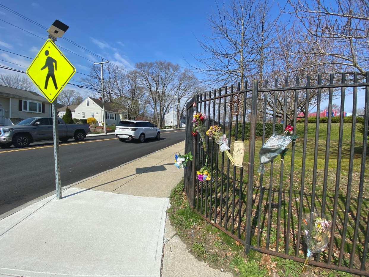 Flowers are left on the fence outside Spencer Borden Elementary School on the corner where Peggy McGowan, a school crossing guard, helped kids cross President Avenue in Fall River.