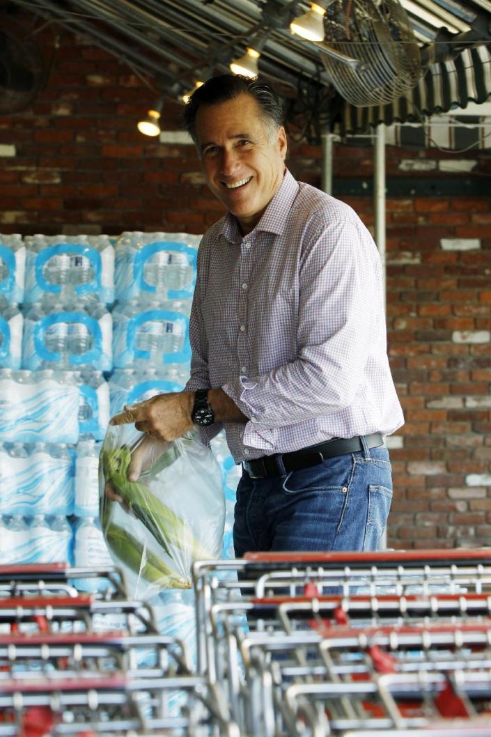 Republican presidential candidate, former Massachusetts Gov. Mitt Romney puts ears of corn into a plastic bag as he arrives at Hunter's Shop and Save supermarket in Wolfeboro, N.H., Monday, Aug. 6, 2012. (AP Photo/Charles Dharapak)