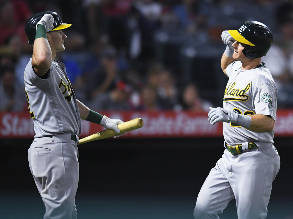 Oakland Athletics' Sean Murphy, left, congratulates Matt Chapman after Chapman hit a solo home run during the eighth inning of the team's baseball against the Los Angeles Angels on Friday, July 30, 2021, in Anaheim, Calif. (AP Photo/John McCoy)